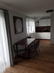 a dining room with a table and chairs and a kitchen at Agroturystyka Koronkowe Zacisze in Koniaków