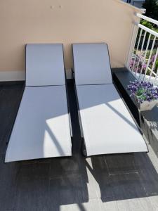 2 sillas blancas en la parte superior de un balcón en Apartments Miriam Srima, en Vodice