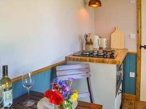 a table with a vase of flowers and a bottle of wine at Wildflower View in Lowthorpe