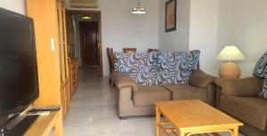 ein Wohnzimmer mit Sofa und Tisch in der Unterkunft 2 bedroom apartment overlooking Mediterranean, 2 outdoor pools in Mijas Costa