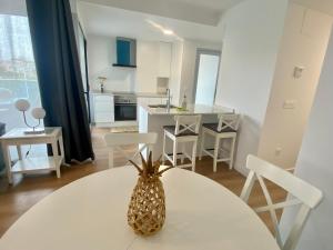 Una cocina con una mesa con una piña encima. en VerdeMar 5 (Playa Puerto de Sagunto), en Puerto Sagunto