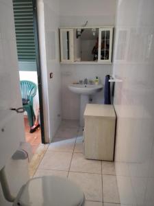 Baño blanco con aseo y lavamanos en CASA ARTE, en Torre Pali