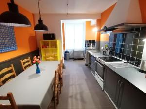 a kitchen with orange walls and a white counter top at Le gite de la Licorne in Saint-Mihiel