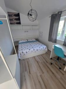 a bedroom with a bed and a desk and a chair at Apartment Mia 2 in Rab