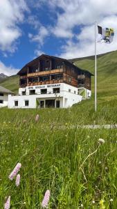 a building in the middle of a field with a flag at Hotel Bergalga in Am Bach