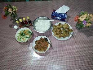 uma mesa com três pratos de comida e arroz em Lorenso Cottage em Manado