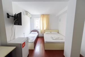 a small room with two beds and a tv at Vila Blue Eforie Nord in Eforie Nord