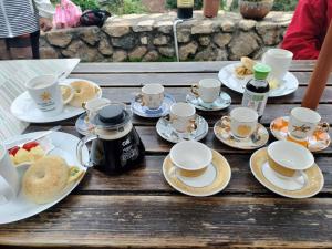 Happy Inn في Juguang: طاولة خشبية مليئة بالأكواب وأطباق الطعام
