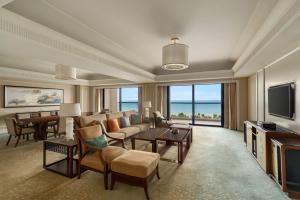 a living room with a couch and a tv at Grand Hotel Haikou - Managed by Accor in Haikou