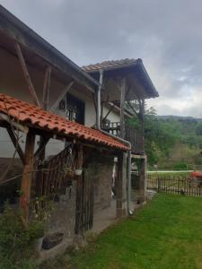 een huis met een veranda en een hek bij Stara planina, smestaj Ćirković in Pirot
