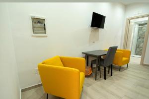 Domus Martì في فورميا: غرفة معيشة مع طاولة وكراسي صفراء