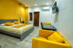 1 dormitorio con 1 cama y 2 sillas amarillas en Domus Martì, en Formia
