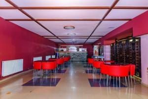 un restaurante rojo con sillas rojas y un bar en EcoRest - Likani Palace, en Borjomi