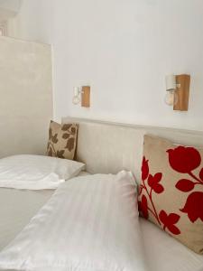 a bedroom with two beds with red flower pillows at Fikas Hotel in Naxos Chora