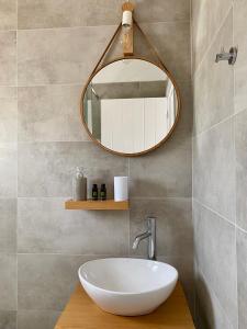 La salle de bains est pourvue d'un lavabo blanc et d'un miroir. dans l'établissement Fikas Hotel, à Naxos Chora