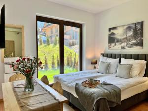 a bedroom with a bed and a large window at Nosal Ski & Wine Apartments in Zakopane