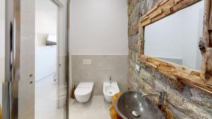 a bathroom with a sink and a toilet and a mirror at Residenze Civitas in Olbia +20 photos
