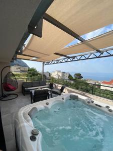Un jacuzzi en un patio con vista al mar. en Apartment Ana, en Makarska
