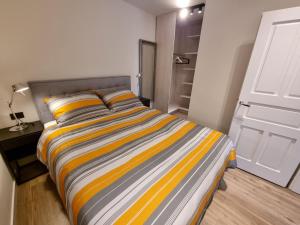 1 dormitorio con 1 cama con rayas amarillas y grises en VIL 2+1, en Crikvenica