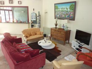 ein Wohnzimmer mit roten Möbeln und einem Flachbild-TV in der Unterkunft Beaux Chênes in Nérac