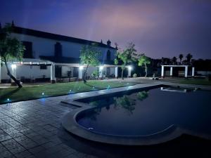 ein Haus mit einem großen Swimmingpool in der Nacht in der Unterkunft Cortijo la amazona in Sevilla