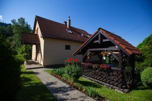 a small house with a flower garden in front of it at Apartmán NIKA in Levoča