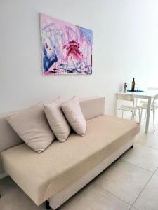 un divano in una stanza con un dipinto sul muro di B&B Lido Apartament 10A a Civitanova Marche