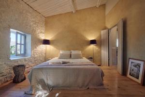 a bedroom with a large bed in a stone wall at Les Sardines aux Yeux Bleus Chambres d'Hôtes in Aigaliers