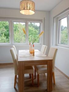 a dining room table with white chairs and a vase on it at La Casa de Marina in Vivero +33 photos