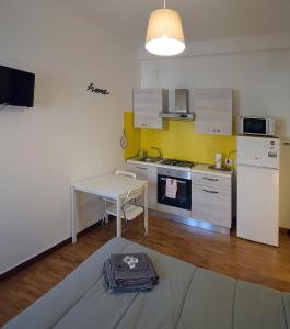 eine kleine Küche mit einem Tisch und einem weißen Kühlschrank in der Unterkunft Ravenna Tourist Apartments in Ravenna