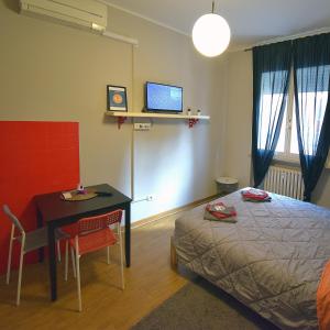 Schlafzimmer mit einem Bett und einem Schreibtisch mit einem Computer in der Unterkunft Ravenna Tourist Apartments in Ravenna