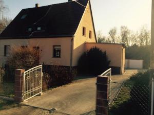 een wit huis met een hek en een hek bij Monteurhaus in Sallgast