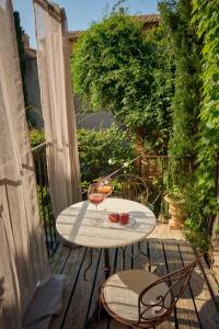 a table with two glasses of wine on a balcony at Les Sardines aux Yeux Bleus Chambres d'Hôtes in Aigaliers