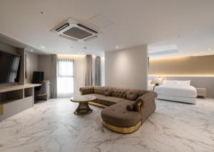 sala de estar amplia con sofá y cama en Gunsan Stay Tourist Hotel, en Gunsan