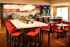 un bar en un restaurante con sillas rojas en Courtyard Toledo Airport Holland, en Holland