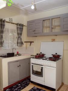 a kitchen with a white stove with pots on it at Elegant Touch Home - 2 Bedroom House in Karen in Nairobi