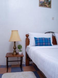 una camera con letto e tavolo con lampada di Elegant Touch Home - 2 Bedroom House in Karen a Nairobi