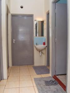 baño con ducha, lavabo y puerta en Elegant Touch Home - 2 Bedroom House in Karen en Nairobi