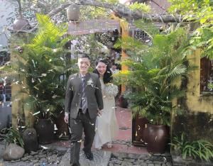 Homestay Da Nang Full House في دا نانغ: عرسان يسيران في الممر في حفل زفافهما