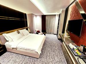 Asur Imperıal Hotel في مِديات: غرفة فندقية بسرير وتلفزيون بشاشة مسطحة