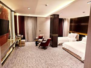 Pokój hotelowy z 2 łóżkami i krzesłem w obiekcie Asur Imperıal Hotel w mieście Midyat