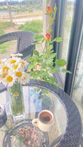 a glass table with a vase of flowers and a cup of coffee at temuka in Samgori