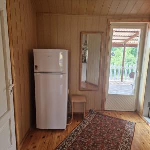 a kitchen with a white refrigerator in a room at Griežto 5 in Zarasai