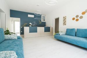 波萨达VeMi Affittacamere的一间带2张蓝色沙发的客厅和一间厨房