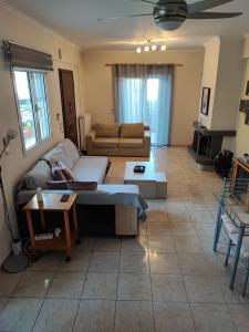 - un salon avec un canapé et une table dans l'établissement A cozy whole house near the airport and the beach, à Artemi