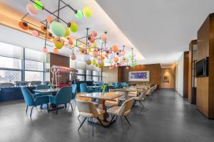 a restaurant with tables and chairs and a chandelier at Minimax Hotel Shanghai Songjiang in Songjiang