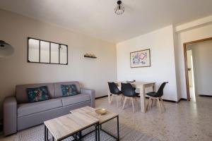 ein Wohnzimmer mit einem Sofa und einem Tisch in der Unterkunft ღ Le Santa Cruz • Spacieux T3 • Parking & Wi-Fi in Pierrelatte