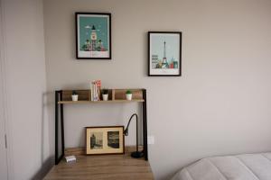 ღ Le Santa Cruz • Spacieux T3 • Parking & Wi-Fi في بييرلات: غرفة بثلاث صور على الحائط وطاولة