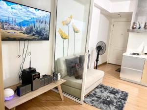 a living room with a television on a wall at Azure Staycation Magical Suite in Manila