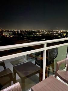 a view of a city at night from a balcony at Azure Staycation Magical Suite in Manila